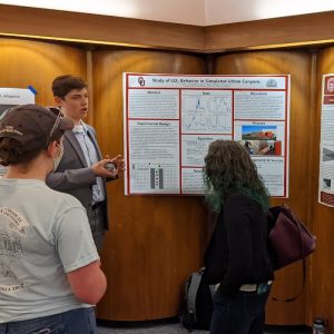 Lucas Livingstone presents a poster of his research to colleagues in meteorology